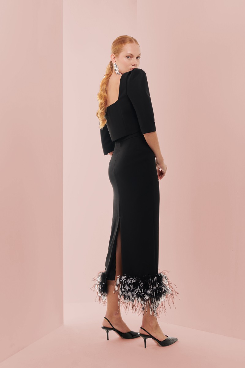 Preciosa falda confeccionada en crepe negro, recta con boas de plumas al tono blanca y negra para invitada a boda, fiesta, evento, invitadas, madrina, shop online apparentia