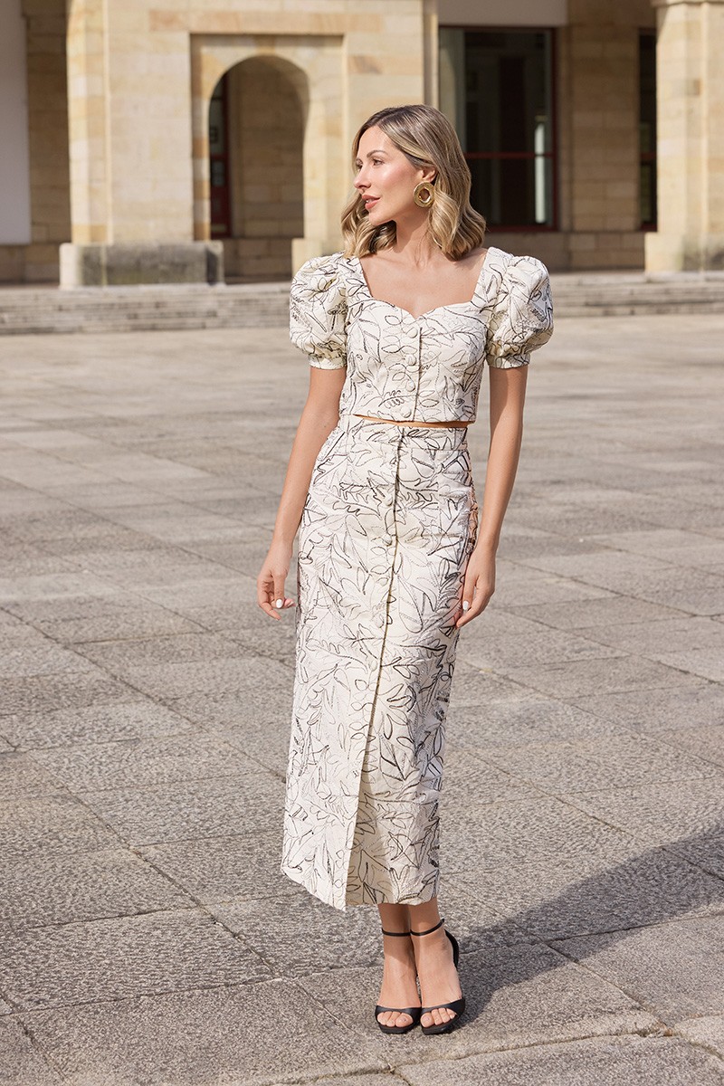 conjunto de falda midi y top manga abullonada confeccionado en lino beige con bordados en relieve de gran calidad.